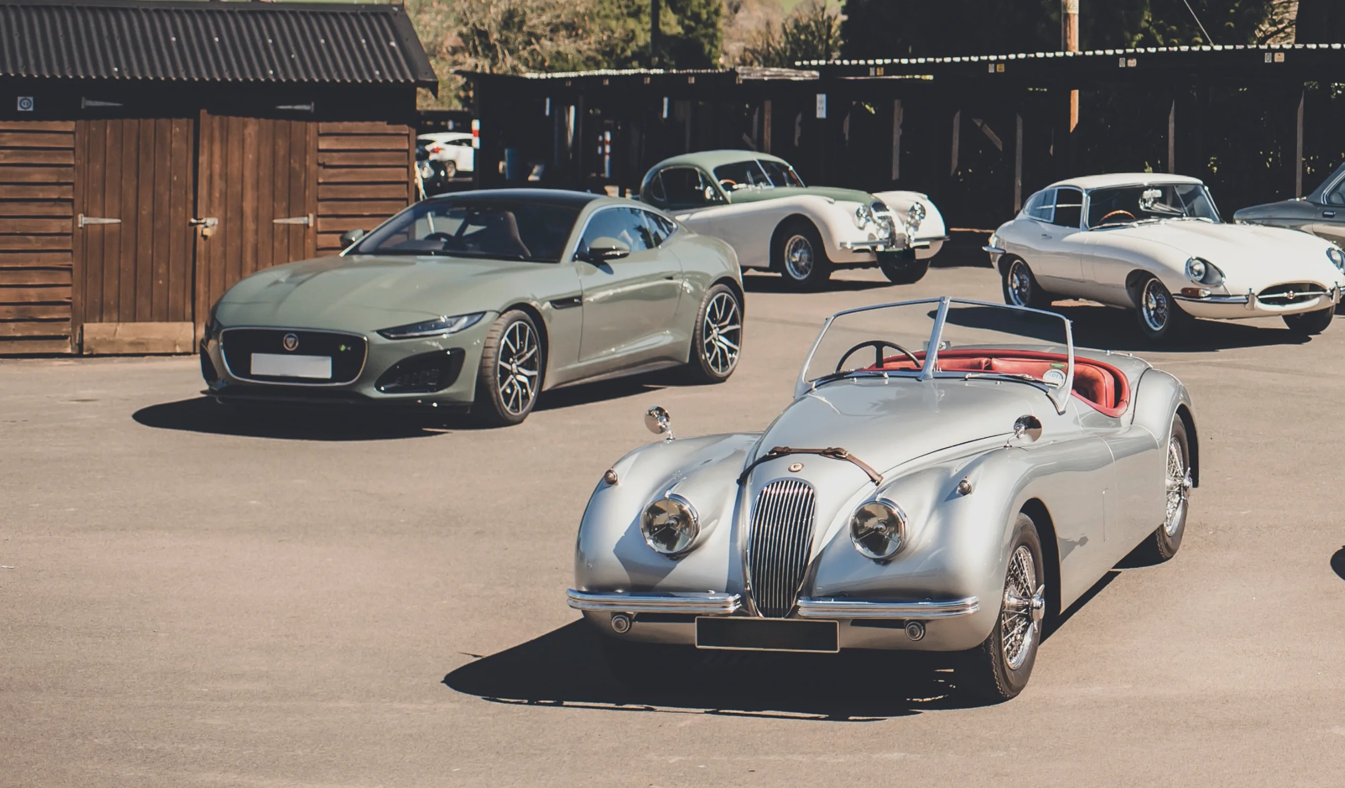 Classic and modern Jaguars outside a workshop